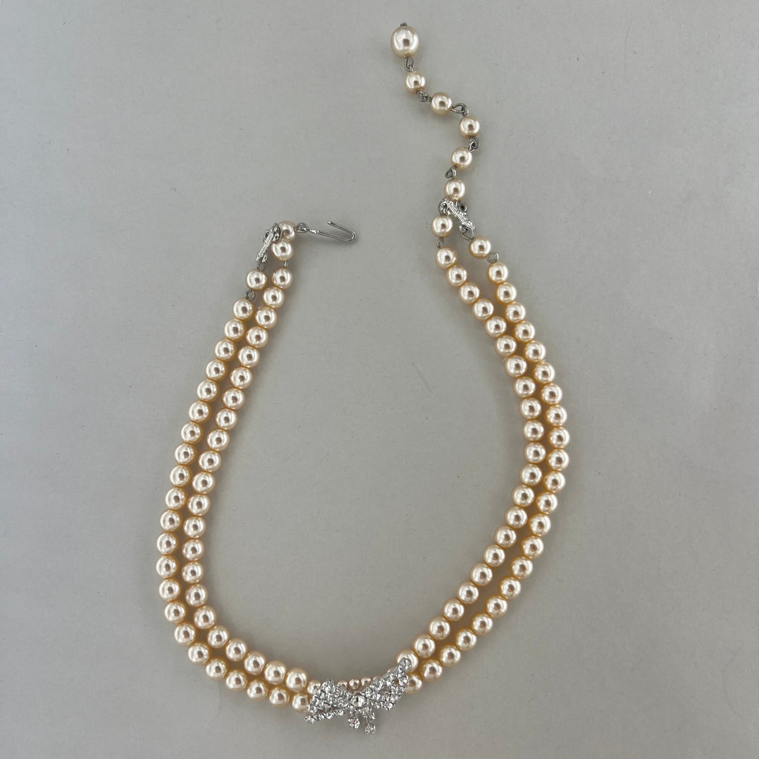 Find Halskæde, choker med beige voksperler og sløjfe vedhæng, forsølvet messing hos Beadhouse of Copenhagen i dag, med en altid hurtig levering!